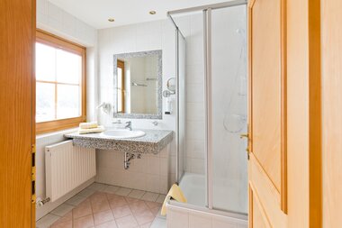 Badezimmer mit Waschbecken und Dusche | © Orange Foto